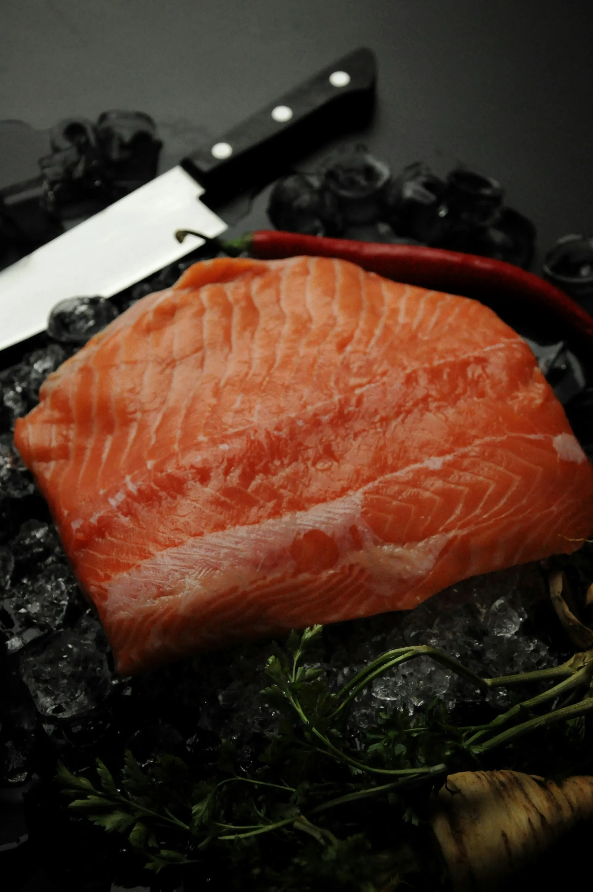 A raw salmon fillet on ice